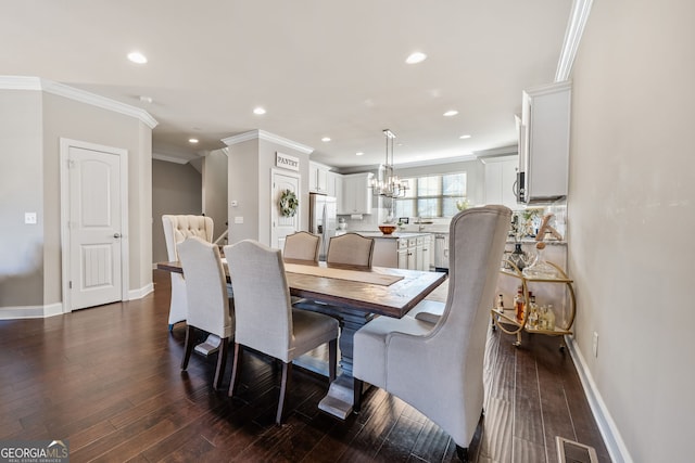 dining space with a notable chandelier, ornamental molding, and dark hardwood / wood-style flooring