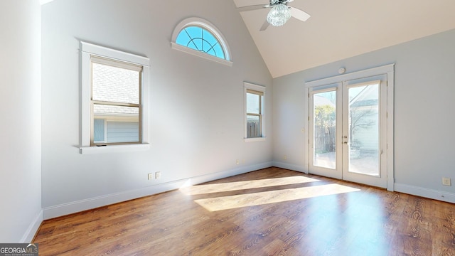 interior space with hardwood / wood-style floors, ceiling fan, high vaulted ceiling, and french doors