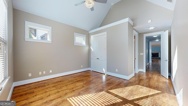 unfurnished room with ceiling fan, high vaulted ceiling, and light wood-type flooring