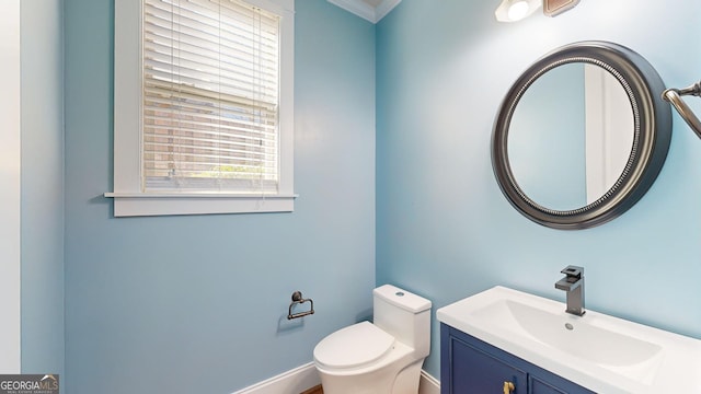 bathroom featuring crown molding, vanity, and toilet