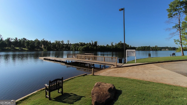 dock area with a yard and a water view