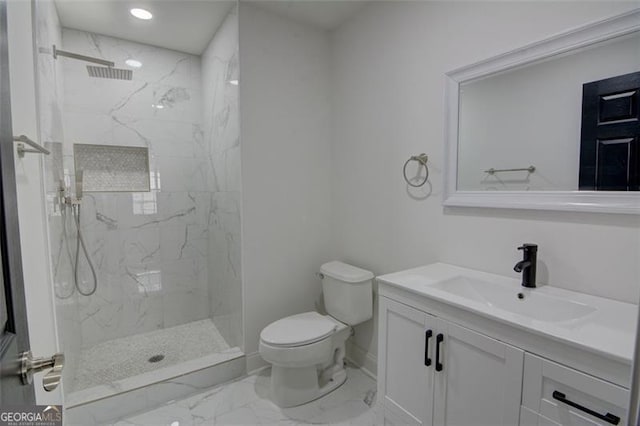 bathroom with vanity, toilet, and a tile shower