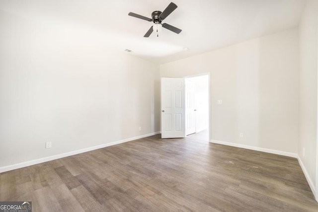 empty room with dark wood-type flooring and ceiling fan