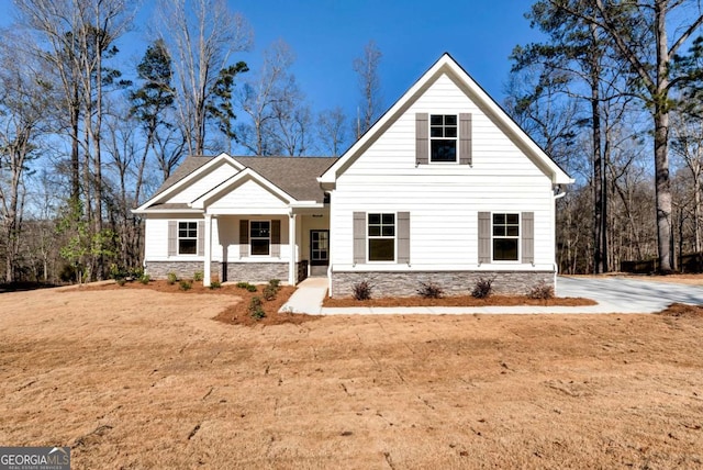 view of front of property featuring covered porch and a front yard