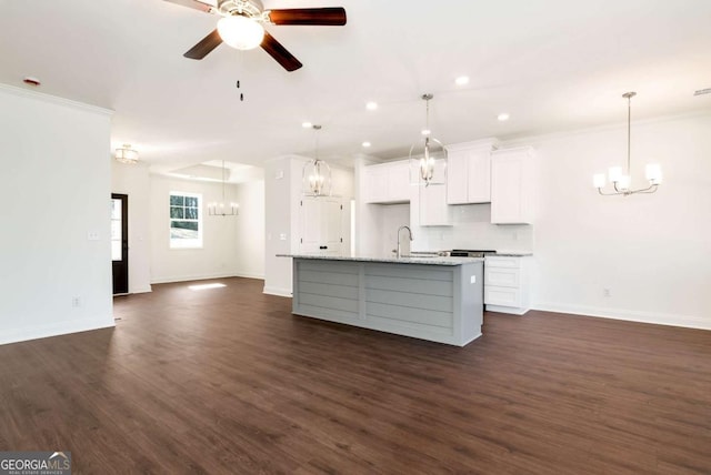 kitchen with white cabinetry, light stone countertops, ceiling fan, an island with sink, and pendant lighting