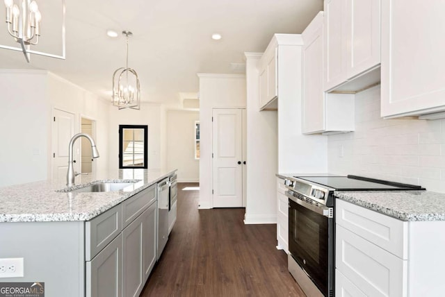 kitchen with a kitchen island with sink, white cabinets, sink, decorative light fixtures, and stainless steel appliances