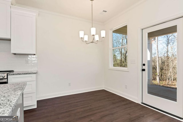 unfurnished dining area with crown molding, dark hardwood / wood-style flooring, and an inviting chandelier