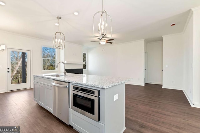 kitchen featuring light stone countertops, stainless steel appliances, sink, hanging light fixtures, and an island with sink