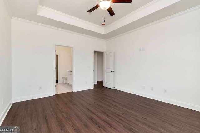 empty room featuring ceiling fan, dark hardwood / wood-style flooring, crown molding, and a tray ceiling