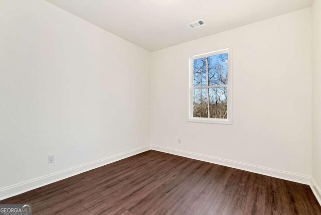 spare room with dark wood-type flooring