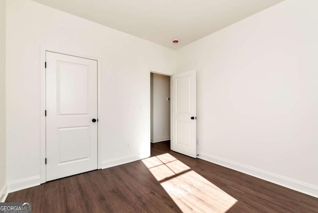 unfurnished bedroom with dark wood-type flooring