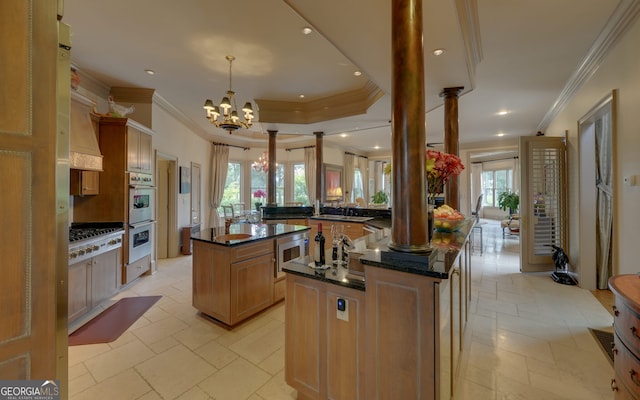 kitchen featuring pendant lighting, an inviting chandelier, a wealth of natural light, a kitchen island, and kitchen peninsula