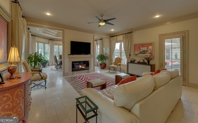 living room with a wealth of natural light, ceiling fan, and ornamental molding