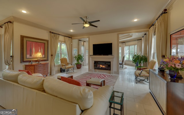 living room featuring ceiling fan, a healthy amount of sunlight, and ornamental molding