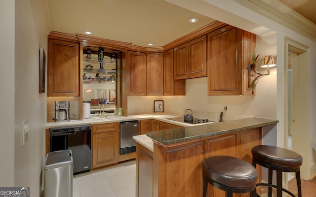 kitchen featuring sink, kitchen peninsula, a breakfast bar area, black appliances, and ornamental molding