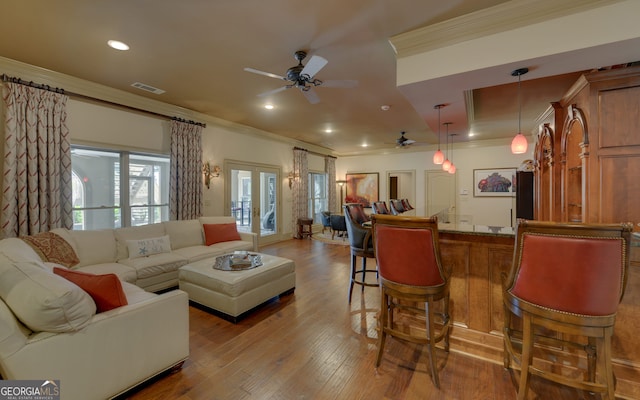 living room with french doors, light wood-type flooring, ceiling fan, and ornamental molding