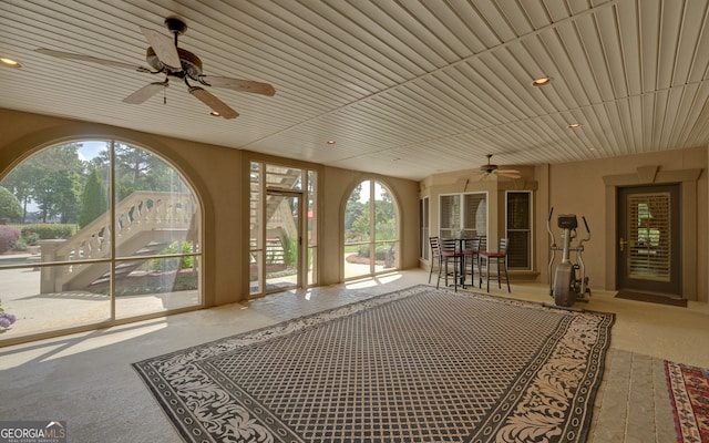 unfurnished sunroom with ceiling fan