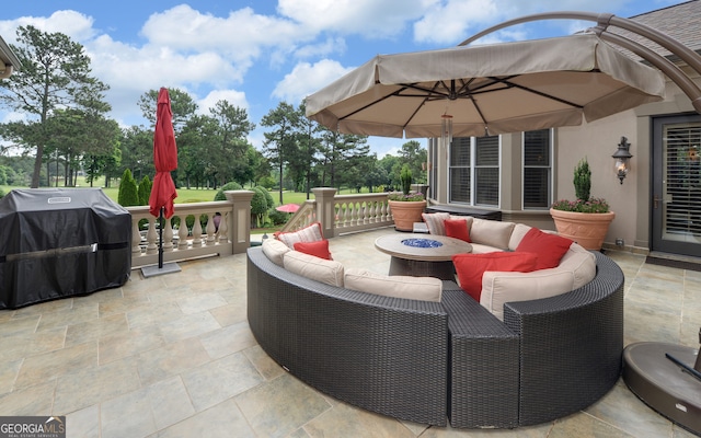 view of patio with grilling area and an outdoor living space with a fire pit