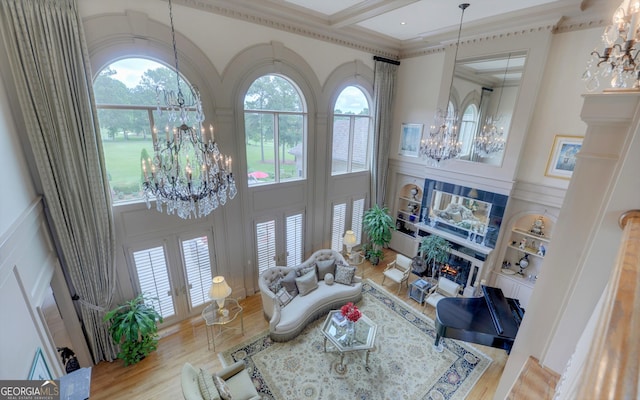 living room featuring wood-type flooring, a towering ceiling, and an inviting chandelier