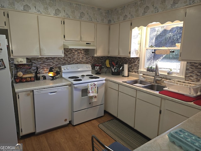 kitchen featuring backsplash, sink, dark wood-type flooring, and white appliances