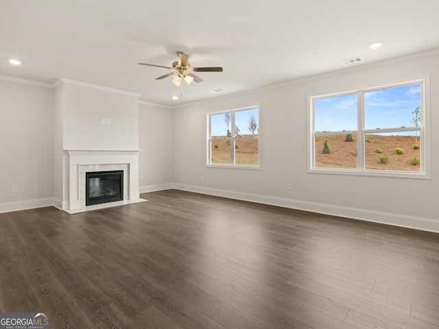 unfurnished living room with a fireplace, dark hardwood / wood-style floors, ceiling fan, and crown molding