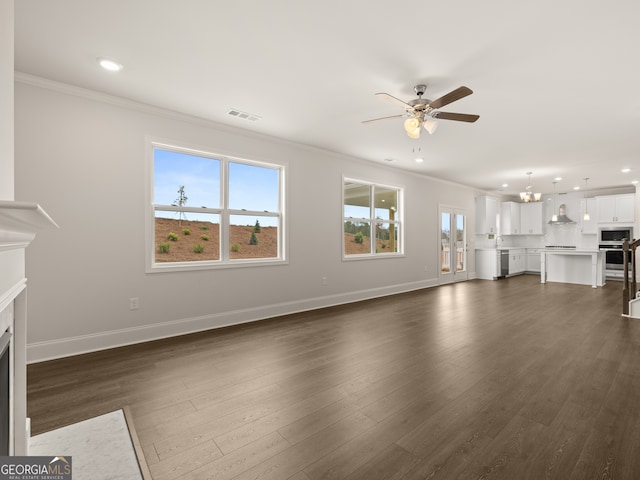 unfurnished living room with dark hardwood / wood-style flooring, ceiling fan with notable chandelier, and ornamental molding