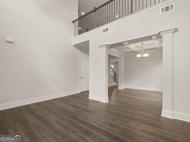 unfurnished living room with dark hardwood / wood-style flooring, coffered ceiling, a notable chandelier, beamed ceiling, and a high ceiling