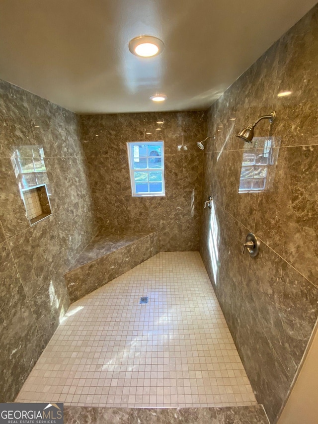 bathroom featuring a tile shower and tile patterned flooring