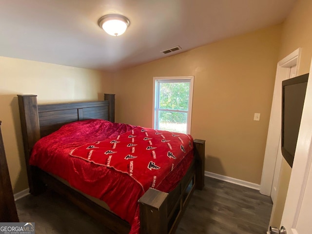 bedroom featuring dark wood-type flooring and vaulted ceiling