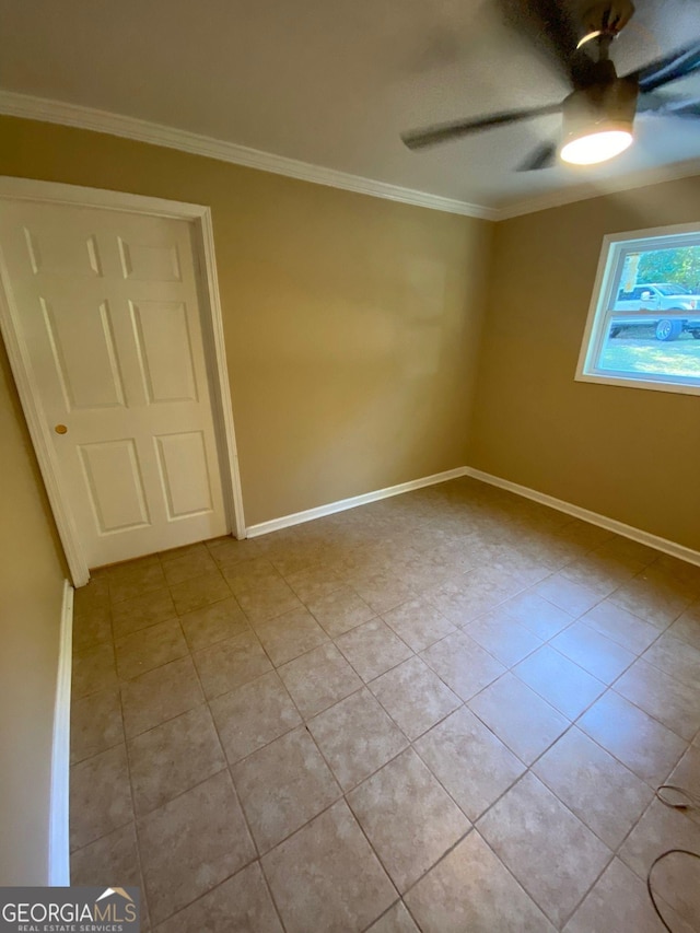 tiled spare room featuring ceiling fan and ornamental molding