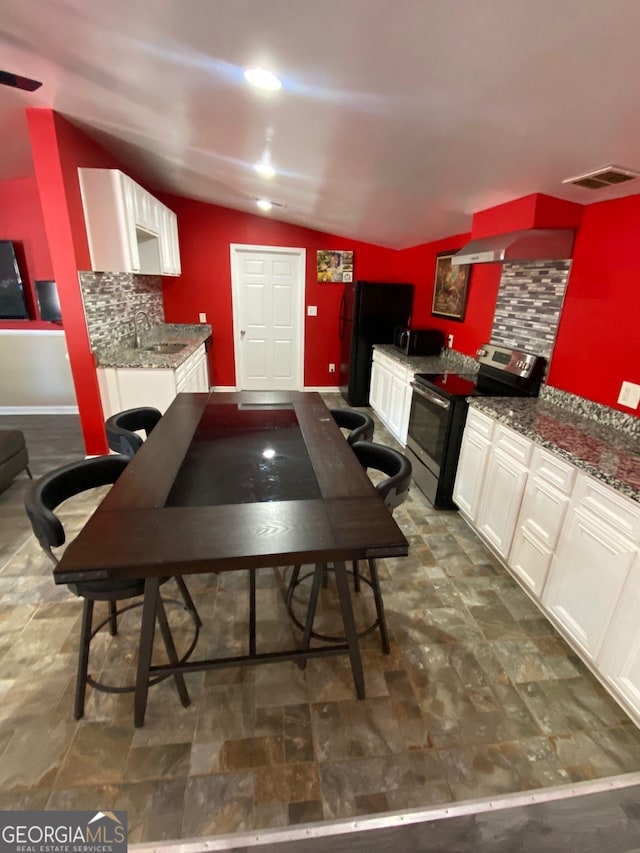 kitchen featuring lofted ceiling, backsplash, extractor fan, and stainless steel electric range