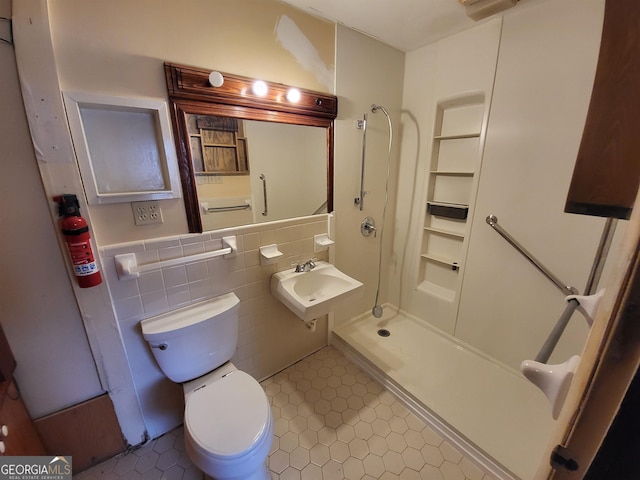 bathroom with toilet, sink, tile walls, and walk in shower