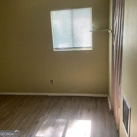 spare room with wood-type flooring