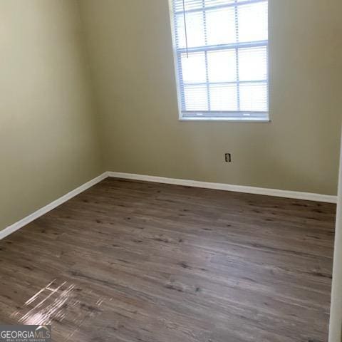 spare room with dark wood-type flooring