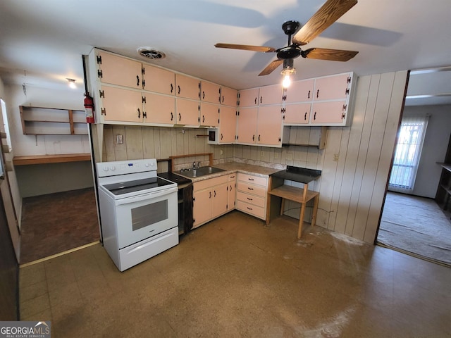 kitchen with electric range, ceiling fan, white cabinets, and sink