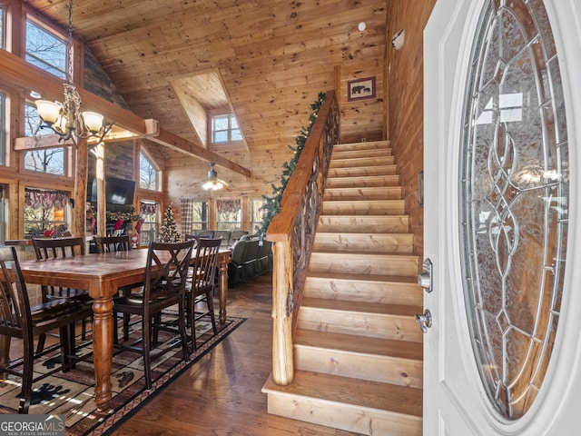 dining room with ceiling fan with notable chandelier, dark hardwood / wood-style floors, high vaulted ceiling, and wood ceiling