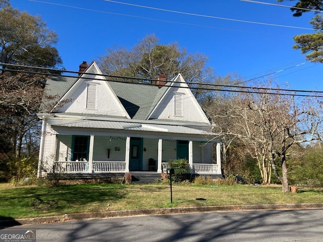 view of front of house with a front yard and covered porch