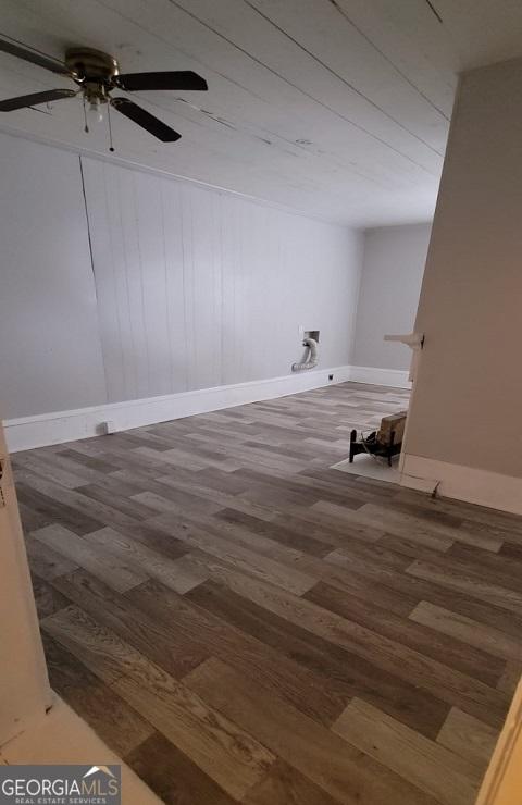 empty room with a ceiling fan, baseboards, and wood finished floors