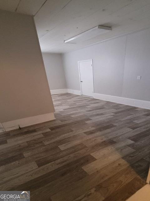 empty room with baseboards and wood finished floors