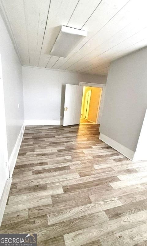 spare room with baseboards and light wood finished floors