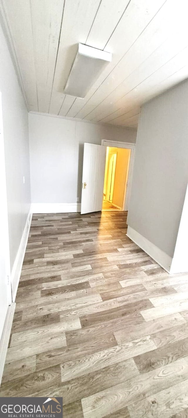 spare room with baseboards and light wood finished floors