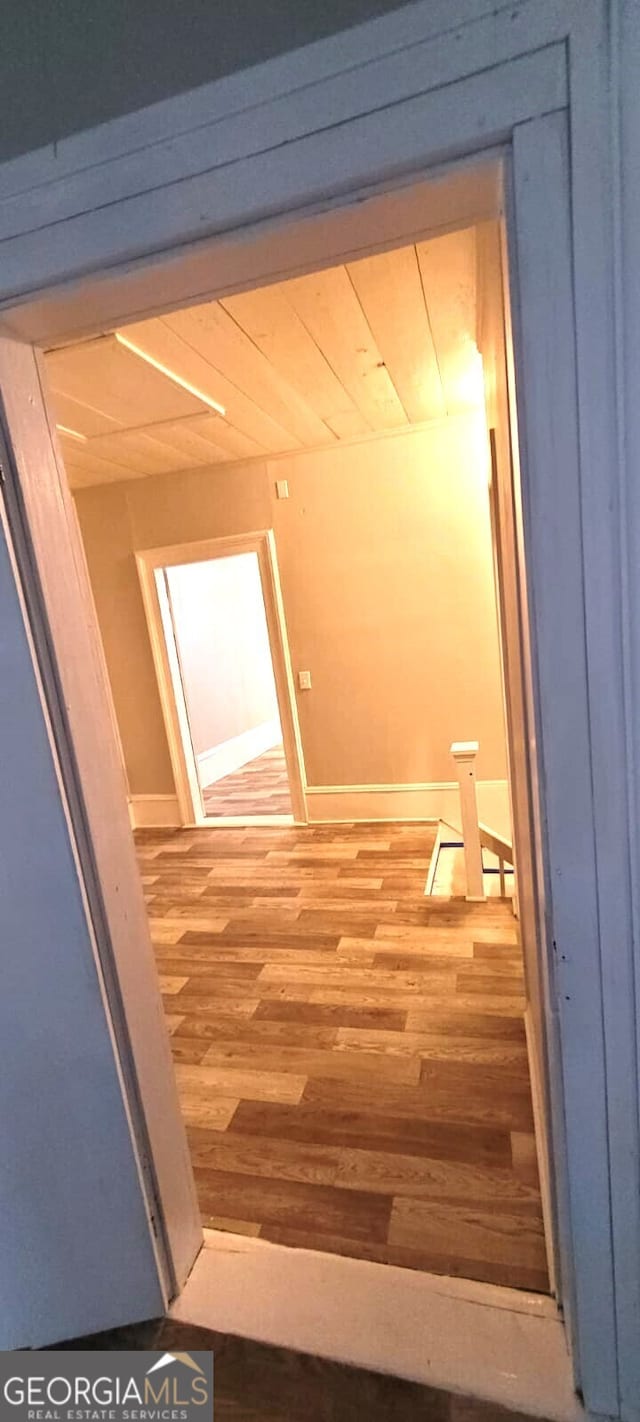 hallway with light wood-type flooring and baseboards