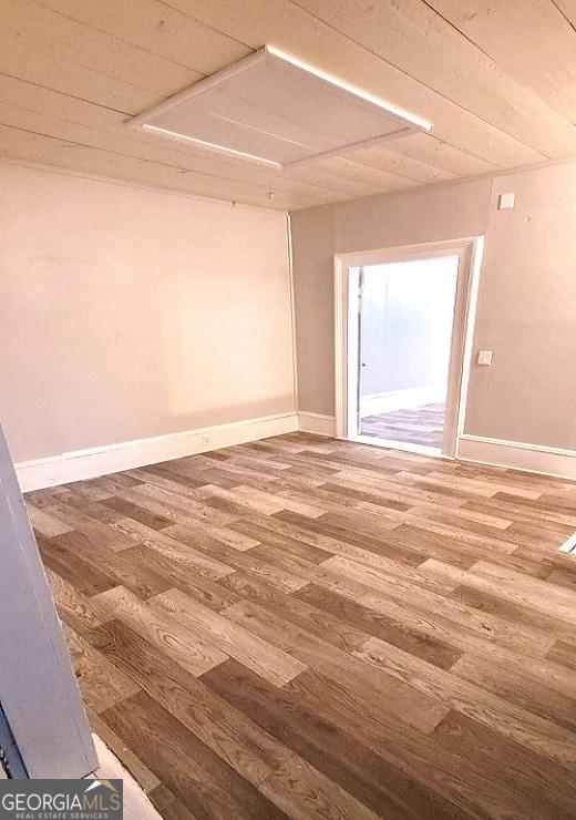 unfurnished room with baseboards and wood finished floors