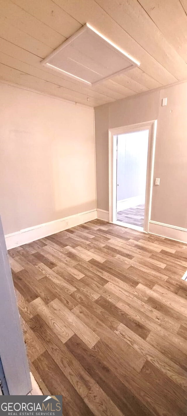 spare room featuring wood finished floors and baseboards