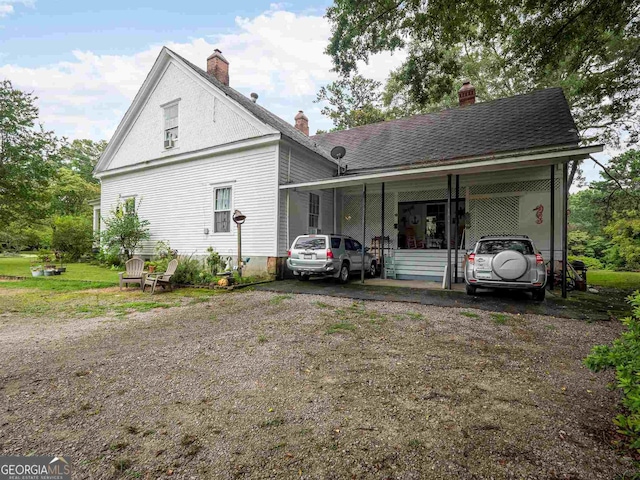 exterior space with a chimney and a shingled roof