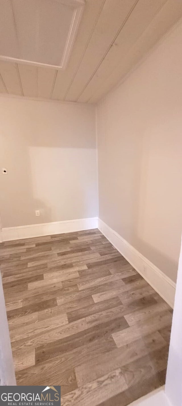 spare room featuring wood finished floors and baseboards