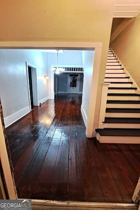 interior space with baseboards, hardwood / wood-style floors, and stairs