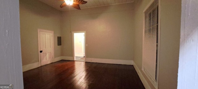 unfurnished room featuring baseboards, a ceiling fan, and dark wood-style flooring