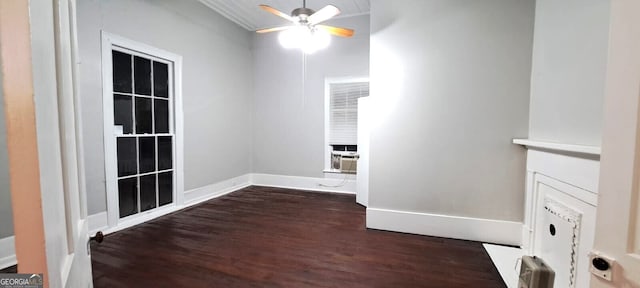 spare room featuring a ceiling fan, dark wood-style flooring, and baseboards