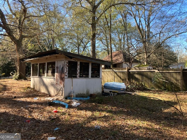 view of outbuilding featuring fence